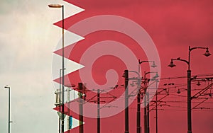 Bahrain flag with tram connecting on electric line with blue sky as background, electric railway train and power supply lines