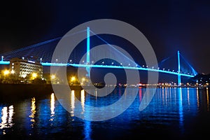 Bai chay bridge in halong bay Vietnam lit up with blue lighting reflecting off water