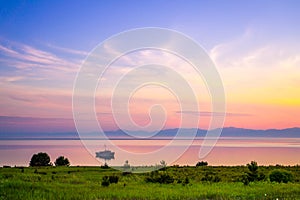 Baikal lake area landscape with boat and mountains silhouette