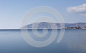 Baikal lake spring landscape view. Snow-covered shore of the lake. Rocky forested coastline.