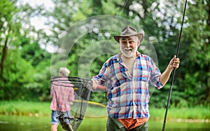 Bait. summer weekend. fishermen with fishing rods, selective focus. retired mature man fisher. hobby and sport activity