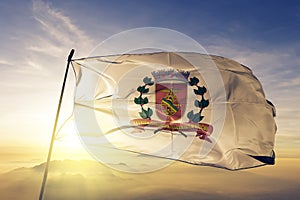 Baixada Santista city of Brazil flag textile cloth fabric waving on the top sunrise mist fog photo