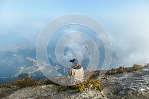 Bajawa - a girl sitting on the top of the volcano, admiring the view photo