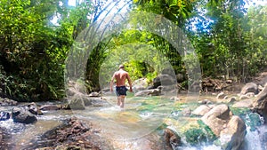 Bajawa - A man walking in the hot river photo