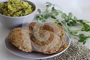 Bajra methi puri. Deep fried Indian flatbread made of pearl millet flour and fenugreek leaves. Served with spiced mashed potato