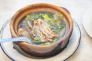 Bak kut teh or Hokkiens topping with golden needle mushroom or Enokitake in Earthenware pot