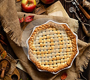 Baked apple lattice pie crust on sackcloth on rustic wooden table