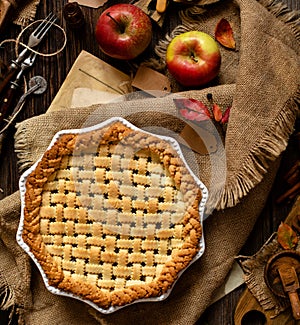 Baked apple lattice pie crust on sackcloth on rustic wooden table