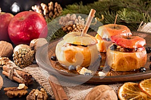 Baked apples on brown plate with holiday Christmas decoration