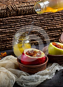 Baked apples pouring honey with nuts and dried berries