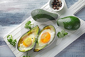 Baked avocado with eggs on table