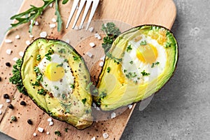 Baked avocado with eggs on wooden board