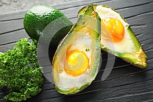 Baked avocado with eggs on wooden board