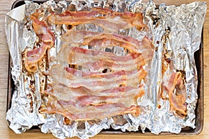 baked bacon strips on foil on cooking sheet