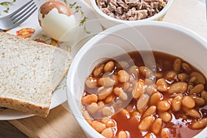 Baked beans in tomato sauce on bowl with bread and tuna steak