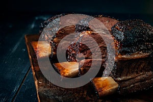 Baked beef brisket on the ribs smoked with a dark crust on a wooden Board. Classic Texas BBQ