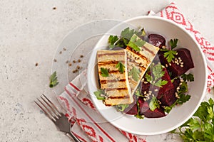 Baked beet salad with grilled tofu parsley and oil in a white bo