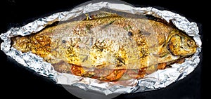 Baked big fish with vegetables in foil