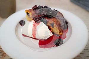 baked blackberries on top of almond and olive cake with cream fresh