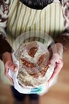 Baked bread, whole-grain sourdough loaf holding hands