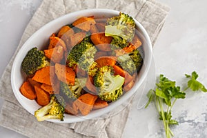 Baked broccoli and sweet potato with spices in white dish, top v