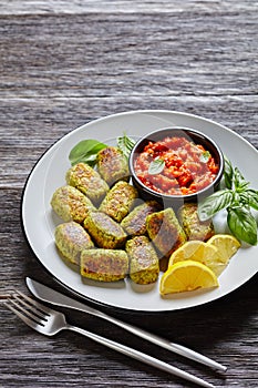 Baked broccoli tots on a grey plate, top view