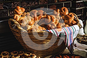 Baked buns, colaci or cakes in straw baskets and towel with rustic motifs. Easter holiday table with traditional bread and