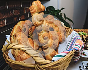 Baked buns, colaci or cakes in straw baskets and towel with traditional Romanian and Ukrainian motifs. Bread in form of snails or