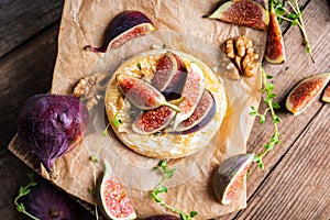 Baked camembert cheese with figs, walnuts, honey and thyme on the rustc background photo