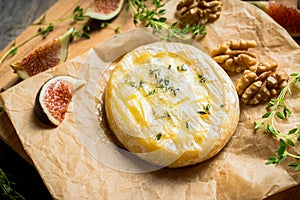 Baked camembert cheese with figs, walnuts, honey and thyme on the rustc background photo