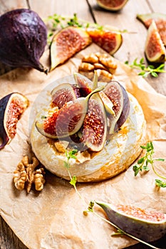 Baked camembert cheese with figs, walnuts, honey and thyme on the rustc background photo