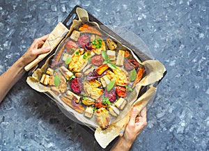 Baked carrots, beets, potatoes, zucchini and tomatoes on a baking sheet, top view food