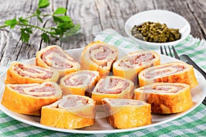 Baked cheese meat Roll-Ups on white dish, close-up