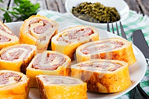 Baked cheese meat Roll-Ups on white dish, close-up