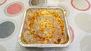 Baked cheese with meatball inside the aluminium foil food container