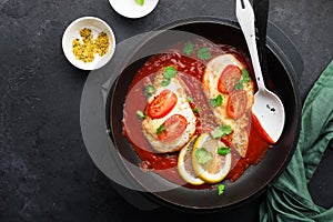 Baked chicken breast with cheese and tomato slices in a juicy tomato sauce on a baking sheet. Top view. Healthy eating,