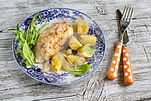 Baked chicken breast with potatoes and onions on a vintage plate