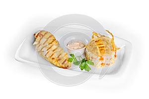 Baked chicken breast with sauce and rice with vegetables on a white rectangular plate on white background