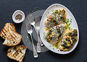 Baked chicken breast with tomatoes, spinach and mozzarella - delicious diet lunch in mediterranean style on a dark background photo
