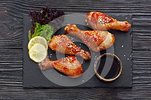 Baked chicken drumsticks served on a stone slate