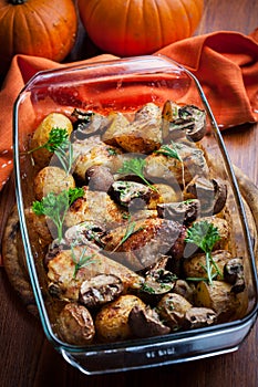 Baked chicken on potatoes and mushrooms