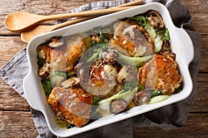 Baked chicken thighs with baby bok choy, cheese and mushrooms close-up. horizontal top view