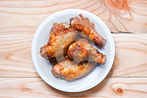 Baked chicken wing bbq grill on plate wood table background - hot and spicy chicken and sauce