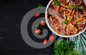 Baked chicken wings in the Asian style on baking dish. Top view, overhead