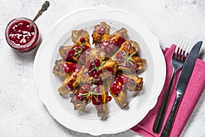 Baked chicken wings in cranberry sauce top view.