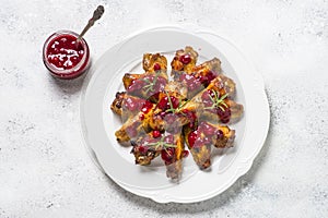 Baked chicken wings in cranberry sauce top view.