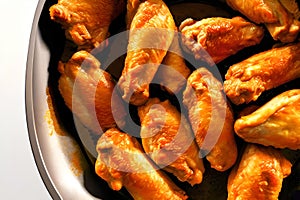 Baked chicken wings in a frying pan. Close-up. Generative AI