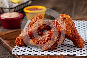 Baked chicken wings with sesame and sauce on wooden background
