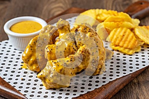 Baked chicken wings with sesame and sauce on wooden background