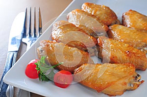 Baked chicken wings white dish cutlery